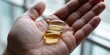 © hobonski - Wellness supplement capsules and golden oil pill in hand for health support and nutrition to achieve physical vitality and daily vitamin body balance.