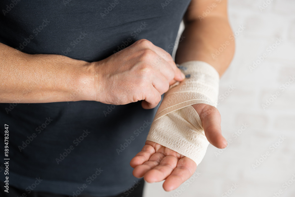 Man's hand wrapping elastic bandage