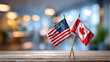 © Анна Терелюк - US and Canada flags on display. Two small flags stand together on a wooden table in a cafe, showing a connection between the United States and Canada.