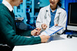 © Nuttapong punna - Doctor explains medical form as patient signs consent in modern clinic. Healthcare, insurance, medical consultation, diagnosis, treatment, documentation concept.