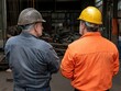 © Tetiana - Two older Caucasian men in hard hats at industrial factory