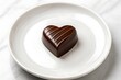 © MS LAIZU - Single heart-shaped dark chocolate on a white plate