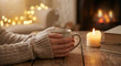 © Nadezda Ledyaeva - Hands in a warm sweater holding a steaming cup of tea near a fireplace, winter comfort or cozy home cafe