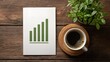 © horizon - Top-down view of a wooden office desk featuring white paper showing a rising green bar graph beside a cup of coffee and green plant leaves.