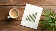 © horizon - Top-down view of a wooden office desk featuring white paper showing a rising green bar graph beside a cup of coffee and green plant leaves.