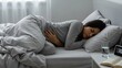 © Amish - Woman sleeping in bed holding stomach while feeling abdominal pain or illness