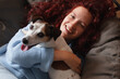 © Tatyana Gladskih - Portrait of Woman having fun with adorable Dog spending leisure time on sofa at home