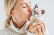 © Tatyana Gladskih - Woman holding kitten cat with blue eyes and kiss him