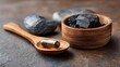 © backup_studio - Activated charcoal capsule on wooden spoon with charcoal pieces in a bowl. Natural detoxification and healthy supplement concept.