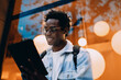 © BullRun - Man smiles while working on a tablet in a tech-friendly urban setting. Shows joy in digital creativity and mobile productivity in today’s connected lifestyle and flexible work culture.