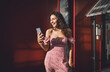 © BullRun - Happy Hispanic woman with smartphone smiles warmly at screen, embodying authentic digital connection, mobile communication, and casual joy in modern freelance lifestyle.