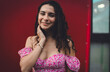 © BullRun - Smiling Hispanic woman touching her neck while looking at camera, radiating authenticity and feminine charm, perfect for themes of confidence, self-love, and approachable modern identity.