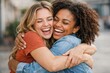 © justjupiter - Two joyful women embracing and laughing together outdoors.