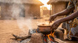© Aurora Aesthetics - African tribal woman cooking traditional meal over open fire outdoors village kitchen lifestyle culture background copy space smoke clay pot indigenous domestic life