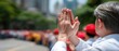 © pvl0707 - Close-up of an old malay man's hand in prayer during a religious ceremony at a Chinese New Year celebration with red caps in the background