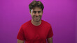 © Krakenimages.com - Man smiling with visible face and red t shirt in a purple studio, casual upright pose and light stubble; friendly confidence.