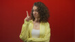 © Krakenimages.com - Woman pointing finger to chest with folded arm, wearing yellow shirt showing visible chest in red studio; skepticism.