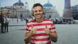 © Krakenimages.com - Young man with headphones giving thumbs up in urban setting of st. peter's square, showcasing a casual and happy vibe with a scenic background in rome's vibrant atmosphere.