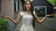 © Krakenimages.com - Teenage woman with long hair shrugs with palms up and worried face in front of a brick building doorway, arms raised in exasperated gesture; frustration.
