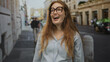 © Krakenimages.com - Young caucasian woman wearing eyeglasses and smiling broadly while standing on a busy urban street; happiness optimism.