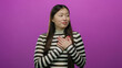 © Krakenimages.com - Woman wearing striped shirt standing confidently with hands on chest against vibrant pink background looking engaging and emotive with long hair and red nails.