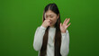 © Krakenimages.com - Woman pinching nose standing against vivid green background closeup exhibiting female emotions with long hair and white sweater portraying isolated discomfort.