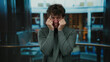 © Krakenimages.com - Hispanic man visibly stressed, crying indoors in an elevator, capturing a moment of emotional distress and vulnerability in an intimate indoor corporate setting.