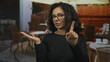 © Krakenimages.com - Middle age hispanic woman extends hand palm open and finger pointing gesture at outdoor cafe terrace; refusal denial.
