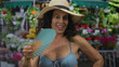 © Krakenimages.com - Woman smiling in bikini with hand fan outdoors at flower shop vibrant scene emphasizing summer vibe.