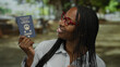 © Krakenimages.com - Woman holding hong kong passport smiling outdoors in urban city street wearing red glasses