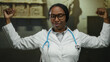 © Krakenimages.com - Confident woman doctor with stethoscope posing triumphantly in museum gallery indoor setting.