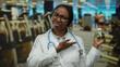 © Krakenimages.com - Female doctor with a stethoscope holds a medication bottle in a gym, looking skeptically at the viewer, highlighting health choices and lifestyle in a medical context.