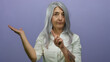 © Krakenimages.com - Senior woman with grey hair, tattooed arm extended, gesturing no with finger against a purple background, conveying caution or disagreement.
