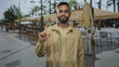 © Krakenimages.com - Man holding index finger up on street terrace restaurant outdoor seating while facing forward; thoughtful reflection.
