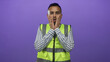 © Krakenimages.com - Man in neon safety vest touching cheeks with hands and looking surprised in studio with purple backdrop; surprise.