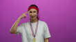 © Krakenimages.com - Woman in casual sportswear with medal appears puzzled against pink background.