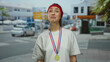 © Krakenimages.com - Woman with medal standing outdoors on city street with a red headband in a casual t-shirt showing funny expression on her face.
