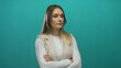 © Krakenimages.com - Woman with arms crossed stands against a vibrant green wall, exuding confidence and calm demeanor, isolated in a studio setting with casual attire and subtle expression.
