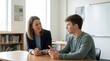 © Studio - Supportive female teacher listening attentively to teenage student discussing future career plans during one-on-one mentoring session in bright modern high school classroom