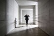 © AspctStyle - Distressed man rushing away through a bright brutalist concrete hallway with strong motion blur effect for mental health crisis concept.