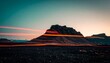 © Lani - Mesmerizing light trails illuminate a rugged mountain landscape under a twilight sky, capturing the essence of motion and time