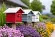 © kardaska - Colorful beehives attracting honey bee in blooming garden