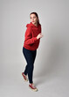 © faestock - full length figure of female model wearing  basic contemporary casual clothing, red hoodie jumper, skinny jeans, sneakers. walking action pose, isolated white studio background.