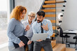 © Novak - Multigenerational business team with senior female leader and young colleagues working in the office.