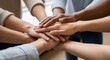 © Clara Elizabeth - Diverse group of people stacking hands together in a gesture of unity and teamwork symbolizing collaboration and support.