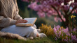 © Maksym - Faceless person reading a book under a tree in spring, soft sunlight, shallow focus, peaceful seasonal activity