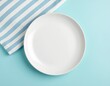 © uumm - 水色のテーブルの上の白い丸皿｜White round plate on a light blue table