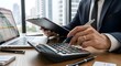 © sultan - Accounting and Financial Planning: Businessman using calculator with clipboard and laptop in office, tax return calculation, bookkeeping and corporate investment concept