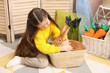 © New Africa - Little girl with cute Easter bunny in wicker basket indoors