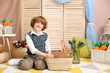 © New Africa - Little boy with cute Easter bunny in wicker basket indoors